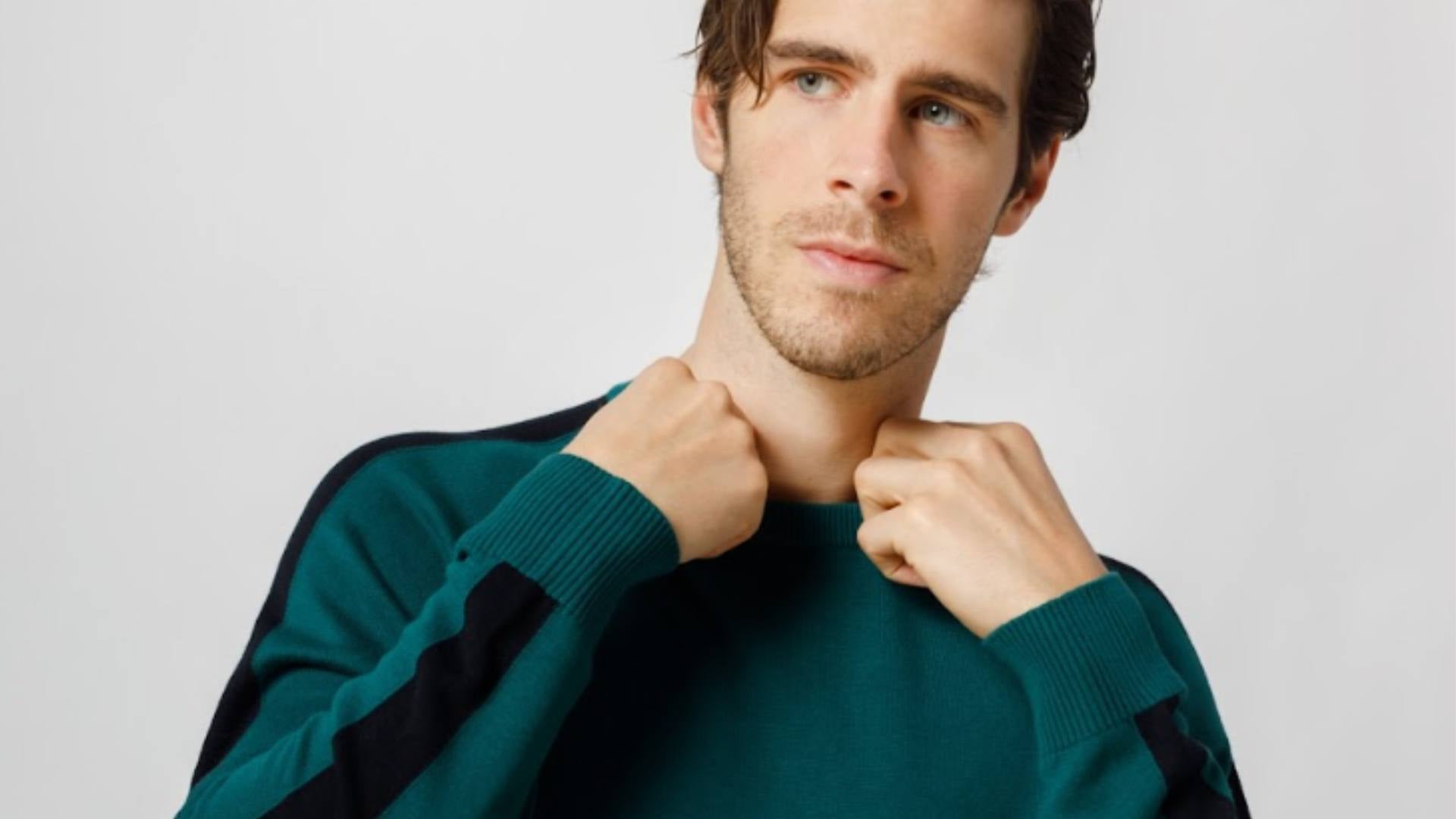 A man stands wearing a green and black shirt, demonstrating eco friendly fashion tips for spring.